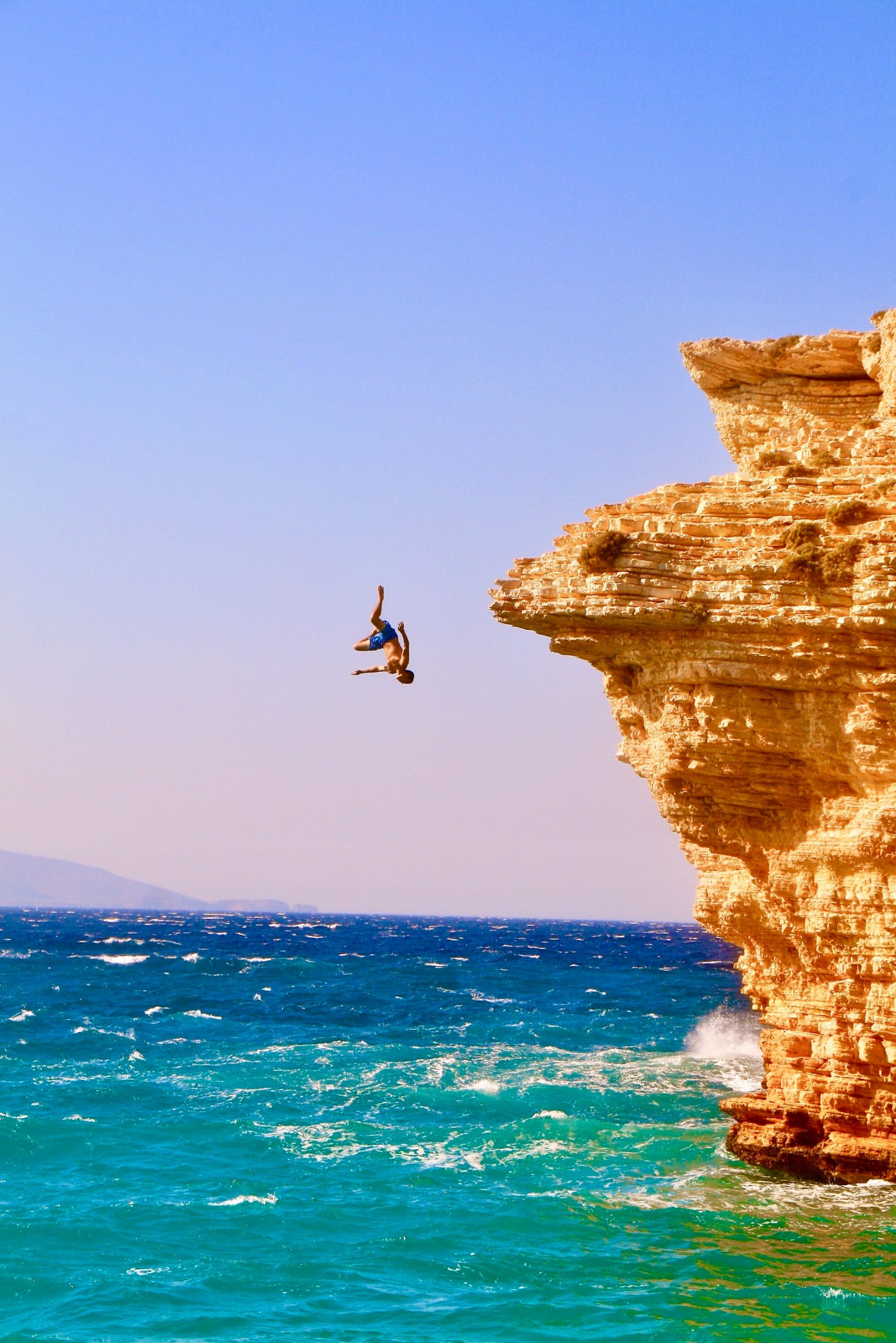 A person cliff diving into the ocean